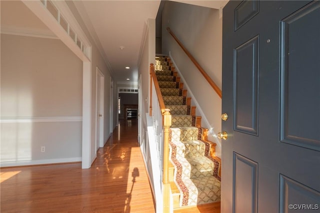 entryway featuring ornamental molding and light hardwood / wood-style floors