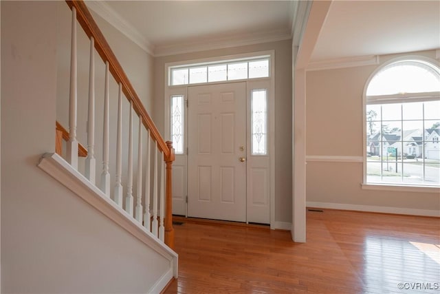 foyer entrance with light hardwood / wood-style flooring and ornamental molding