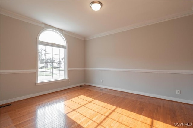 spare room with crown molding and light hardwood / wood-style flooring