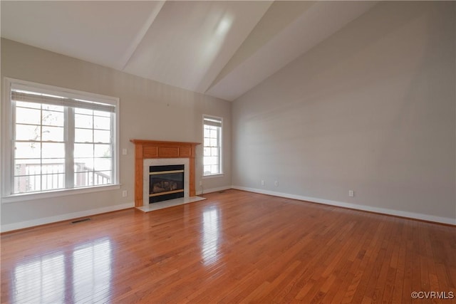 unfurnished living room featuring a fireplace, high vaulted ceiling, and light wood-type flooring