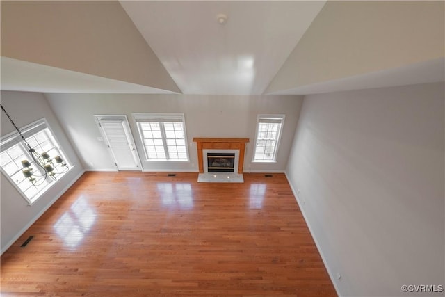 unfurnished living room with high vaulted ceiling and light hardwood / wood-style flooring