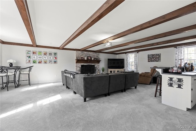 living room featuring a brick fireplace, light colored carpet, and beamed ceiling