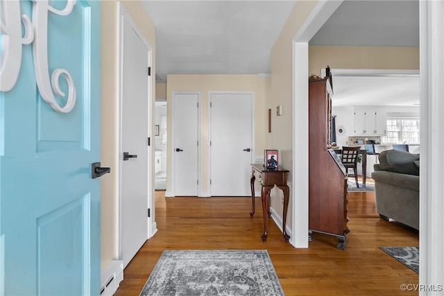 foyer entrance with wood-type flooring and a baseboard heating unit