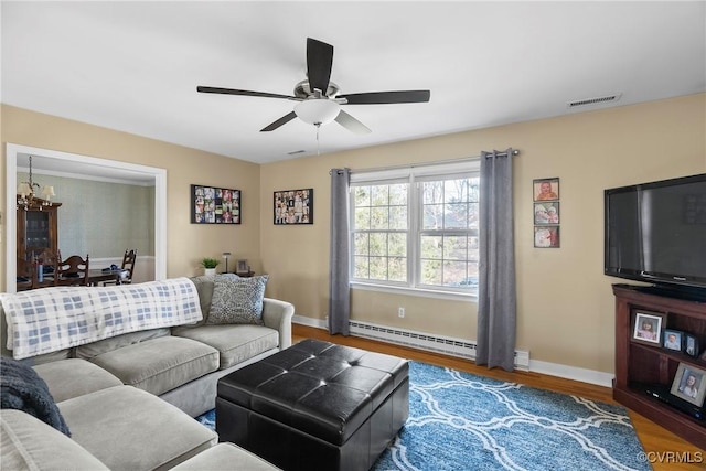 living room with baseboard heating, wood-type flooring, and ceiling fan with notable chandelier