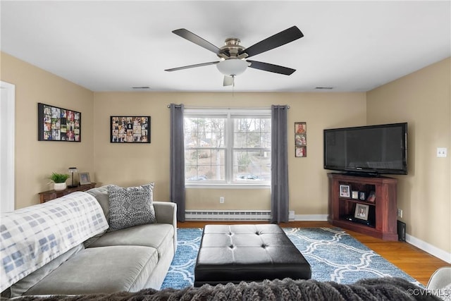 living room featuring ceiling fan, a baseboard radiator, and wood-type flooring