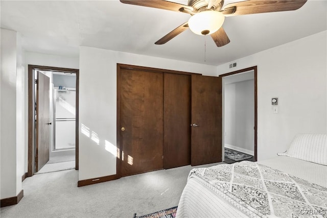 bedroom featuring light colored carpet, a closet, and ceiling fan