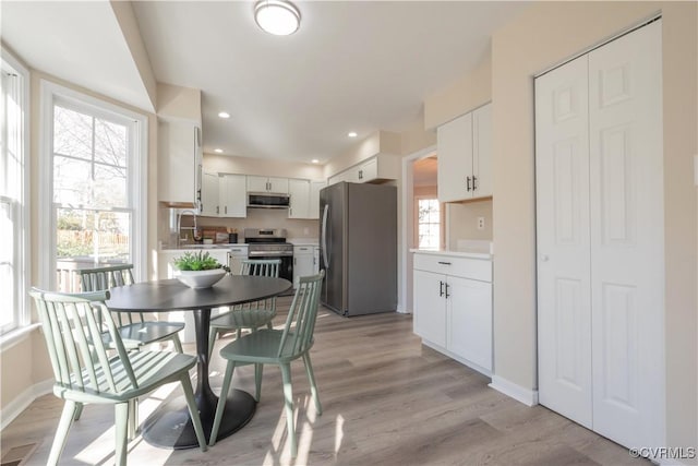 dining area featuring sink and light hardwood / wood-style floors