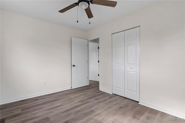 unfurnished bedroom with ceiling fan, light hardwood / wood-style floors, and a closet