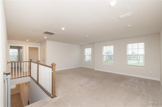 unfurnished room with light carpet and a healthy amount of sunlight