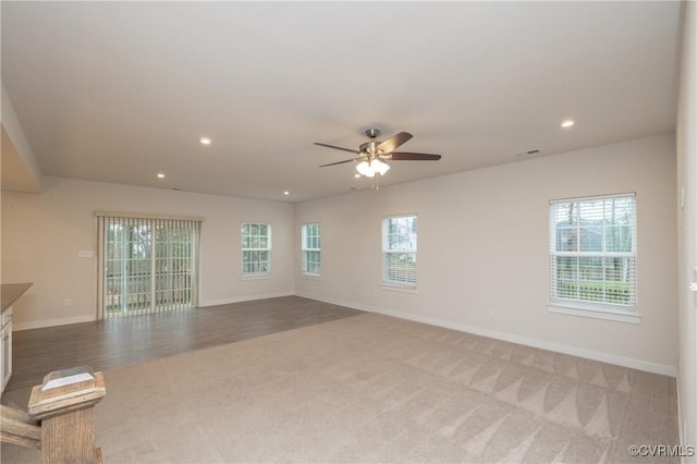 unfurnished living room featuring light colored carpet and ceiling fan