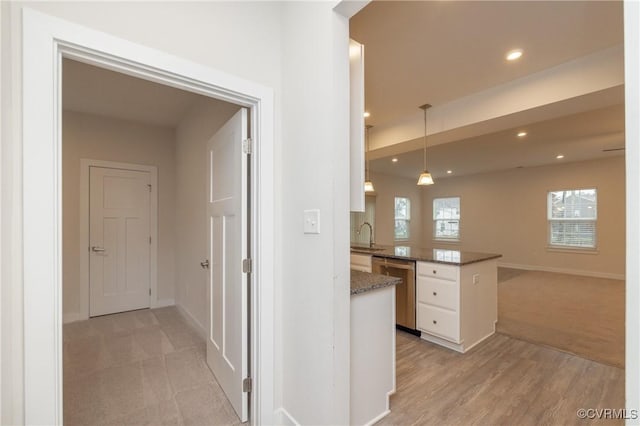 corridor featuring sink and light hardwood / wood-style floors