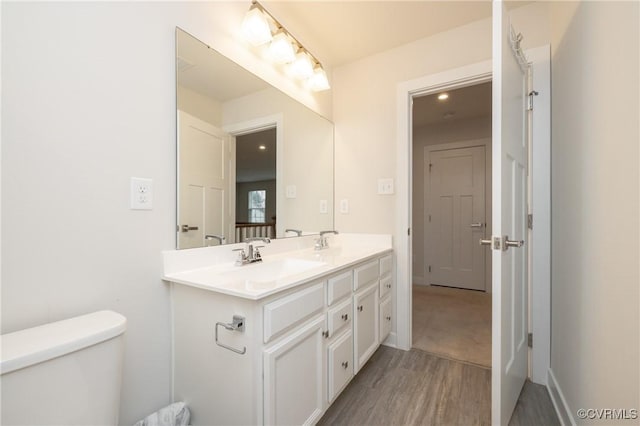 bathroom featuring vanity, wood-type flooring, and toilet