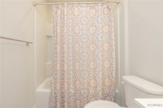 bathroom with shower / bath combo with shower curtain and toilet