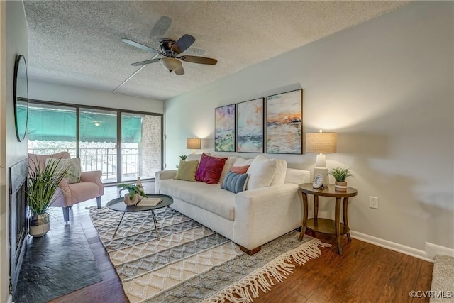 living room with ceiling fan, hardwood / wood-style floors, and a textured ceiling