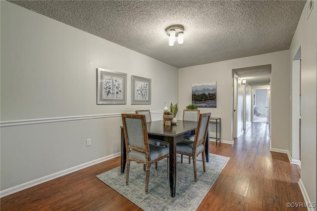 dining room with hardwood / wood-style floors and a textured ceiling