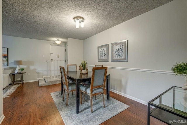 dining space with a textured ceiling and dark hardwood / wood-style flooring