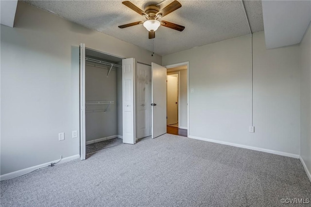 unfurnished bedroom with two closets, a textured ceiling, and carpet flooring