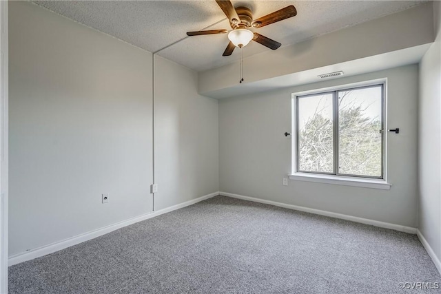 carpeted spare room with a textured ceiling and ceiling fan