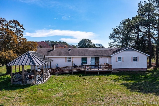 back of house with a gazebo, a wooden deck, and a lawn