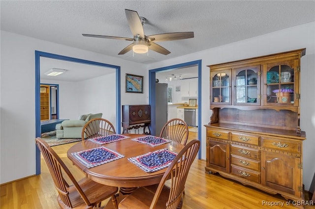 dining area featuring a textured ceiling, ceiling fan, and light hardwood / wood-style flooring