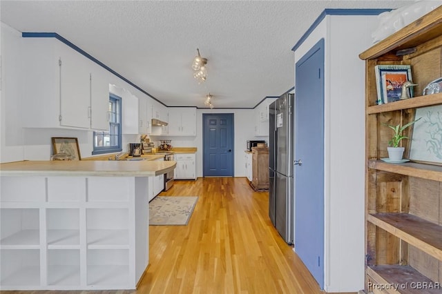 kitchen featuring white cabinetry, a textured ceiling, light wood-type flooring, appliances with stainless steel finishes, and kitchen peninsula