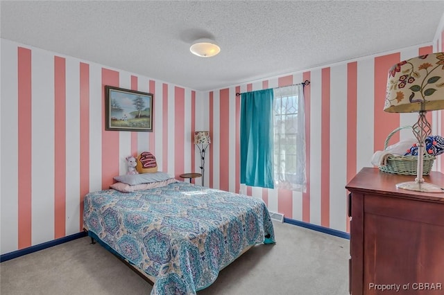 bedroom with light colored carpet and a textured ceiling