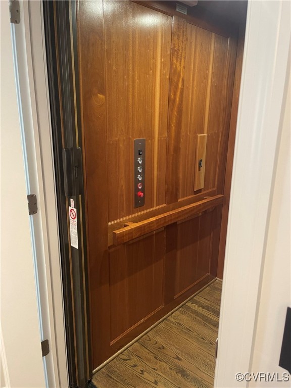 room details featuring elevator and wood finished floors