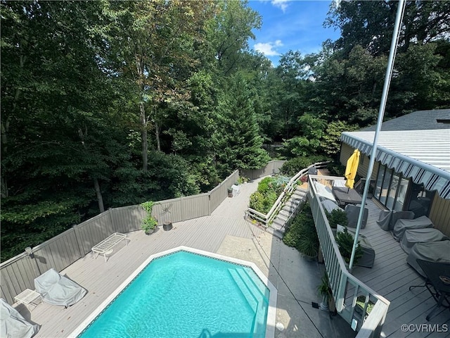 view of swimming pool featuring a fenced backyard, a deck, and a fenced in pool