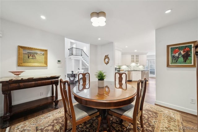 dining area featuring stairs, recessed lighting, baseboards, and wood finished floors