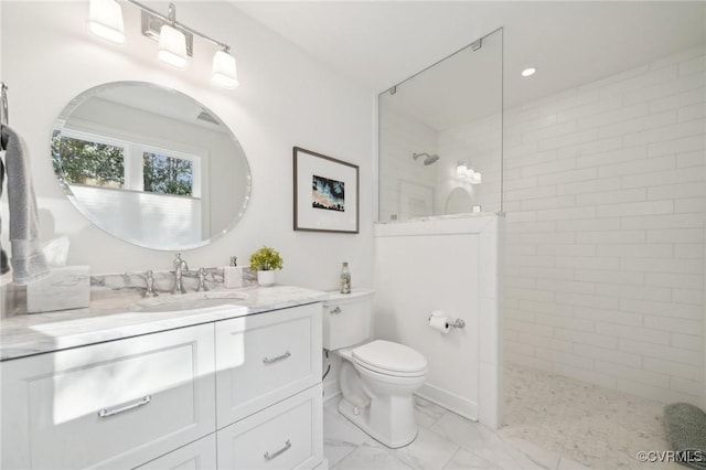 bathroom featuring toilet, marble finish floor, a walk in shower, and vanity