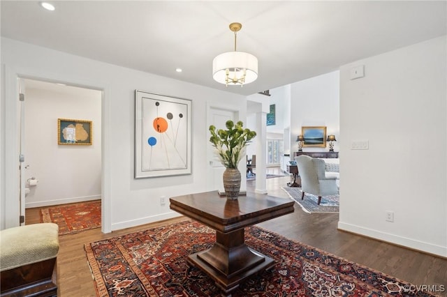 interior space featuring recessed lighting, an inviting chandelier, baseboards, and wood finished floors