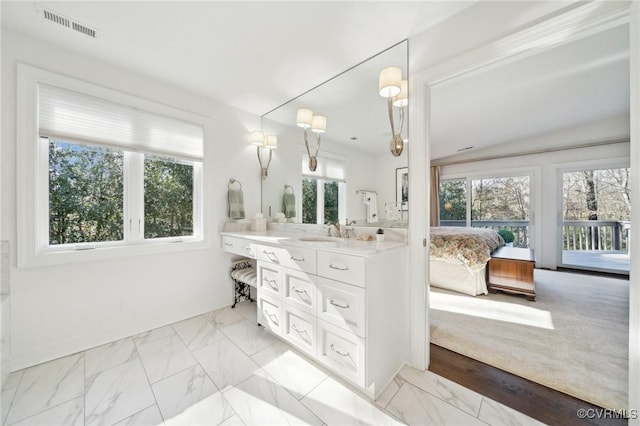 full bath featuring plenty of natural light, marble finish floor, visible vents, and connected bathroom