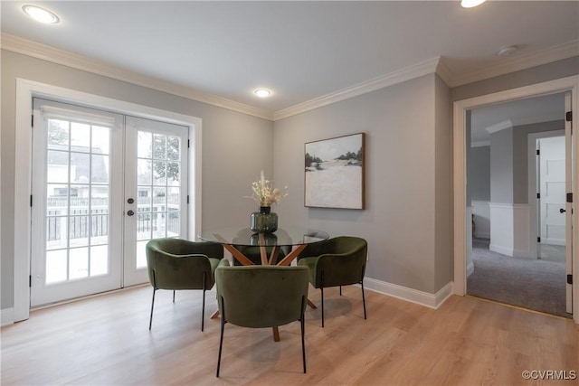 dining space featuring crown molding, a healthy amount of sunlight, light hardwood / wood-style flooring, and french doors