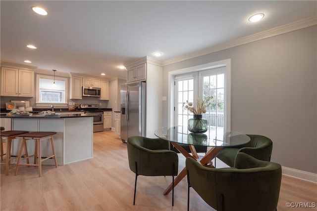 dining space featuring crown molding and light wood-type flooring