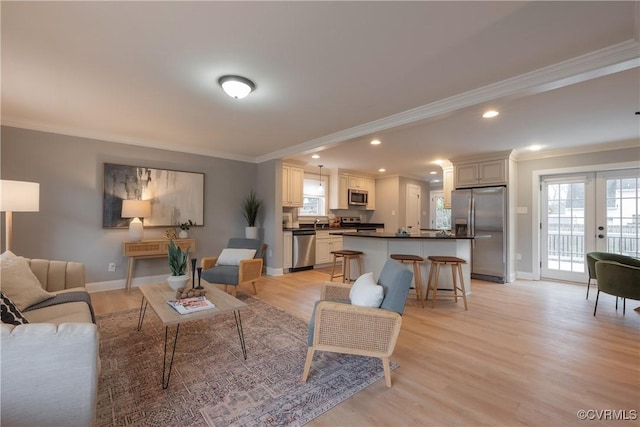 living room with crown molding, light wood-type flooring, and french doors