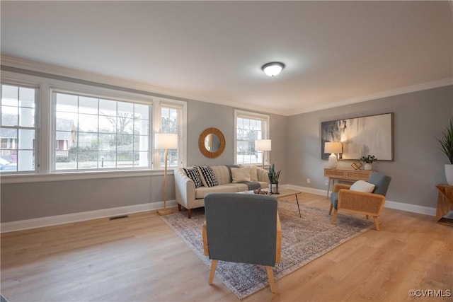 living room with crown molding and light hardwood / wood-style floors