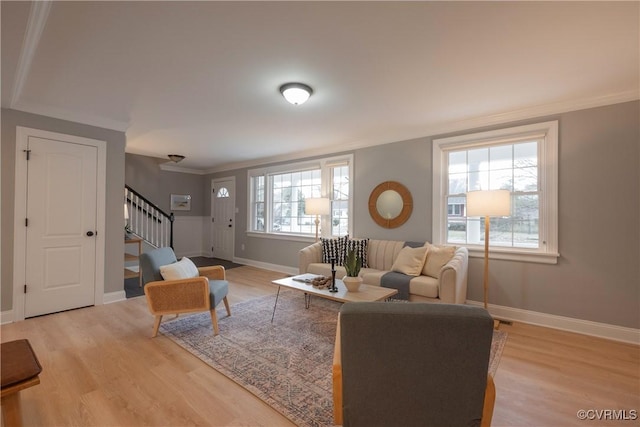 living room with ornamental molding and light wood-type flooring