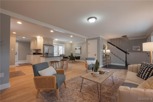 living room featuring crown molding and light hardwood / wood-style flooring