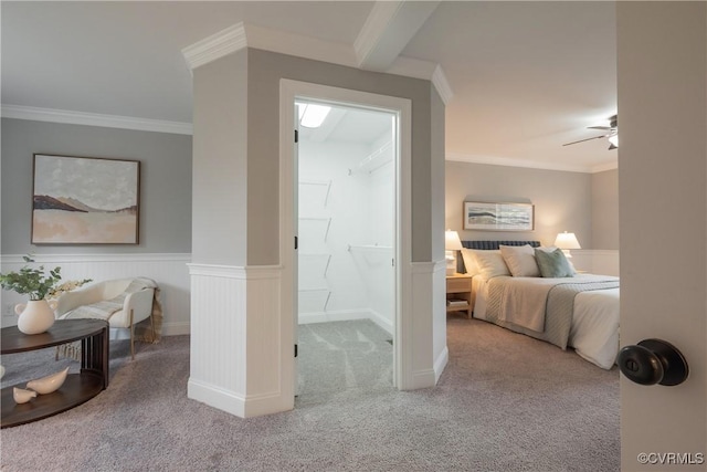 carpeted bedroom with ornamental molding and ceiling fan