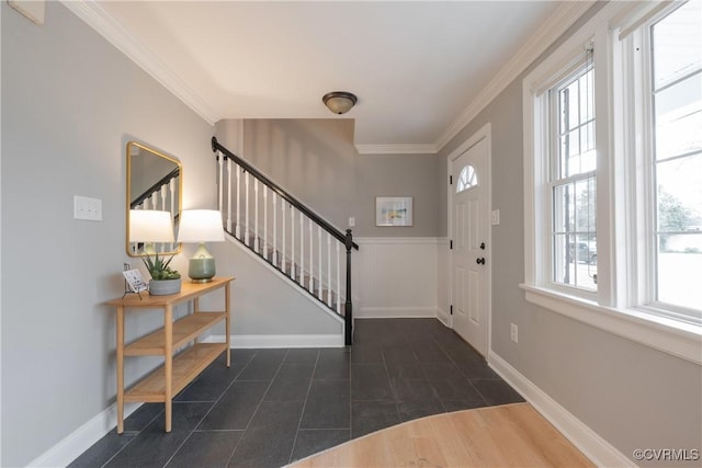 foyer featuring ornamental molding and dark tile patterned flooring