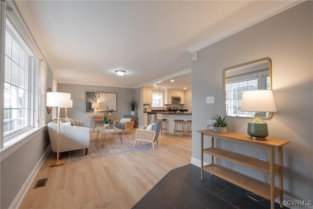 living room featuring ornamental molding and light hardwood / wood-style floors