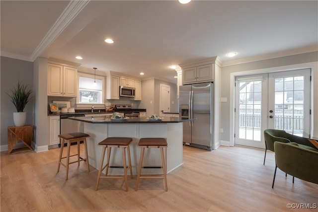 kitchen featuring ornamental molding, appliances with stainless steel finishes, light hardwood / wood-style floors, and decorative light fixtures