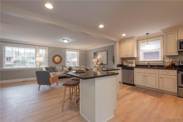 kitchen featuring light hardwood / wood-style flooring, hanging light fixtures, a kitchen island, and appliances with stainless steel finishes