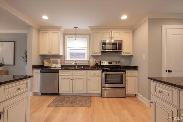 kitchen with pendant lighting, sink, light hardwood / wood-style flooring, stainless steel appliances, and dark stone counters