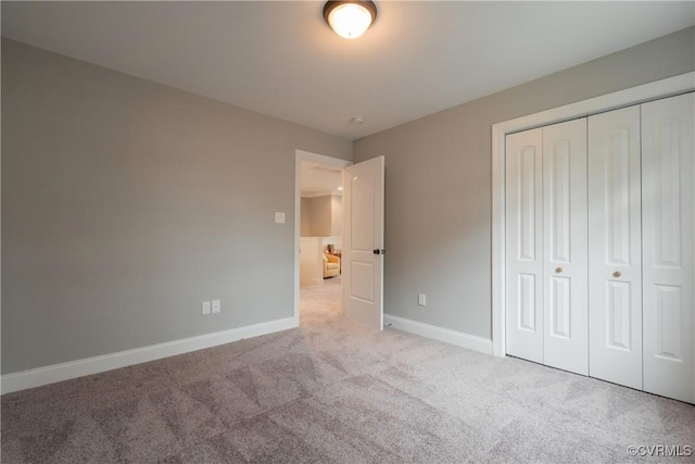 unfurnished bedroom with light carpet and a closet