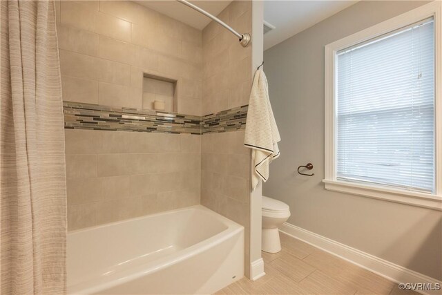 bathroom with shower / bath combo with shower curtain and toilet