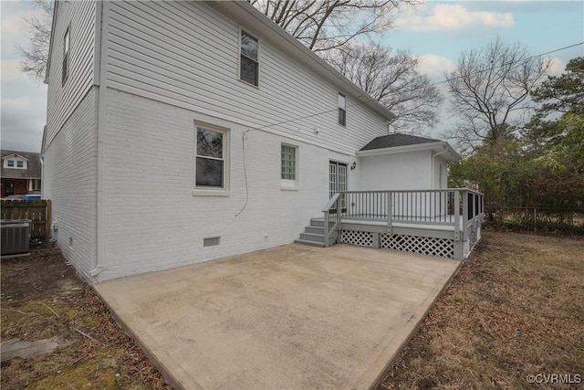 back of property featuring central AC unit, a deck, and a patio area