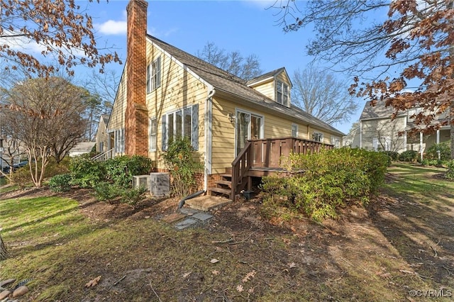 view of property exterior with a wooden deck and cooling unit