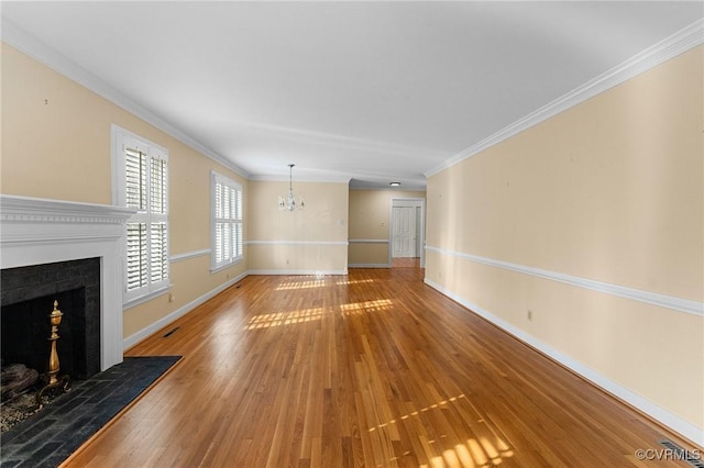 unfurnished living room with crown molding, wood-type flooring, and a chandelier