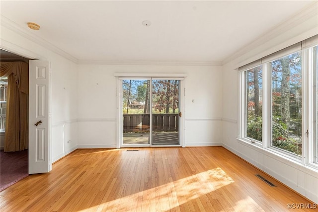 unfurnished room featuring crown molding, a healthy amount of sunlight, and light hardwood / wood-style floors